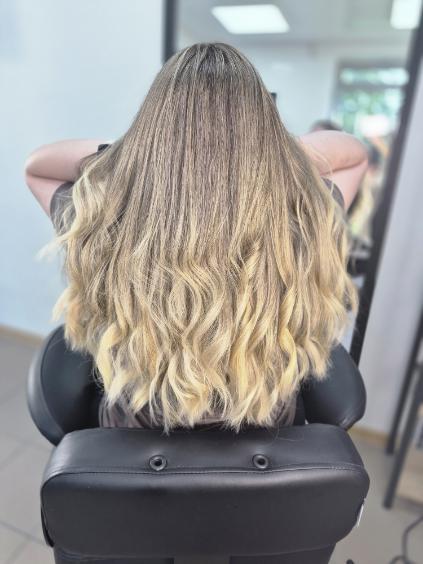 Balayage: miękkie, słoneczne refleksy na falowanych włosach